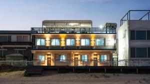 a large building on the beach next to a building at Goseong Jajackdo Aroma Pension in Goseong