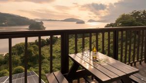 a wooden table with a bottle of wine on a balcony at Yeosu Greenhouse Pension in Yeosu