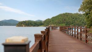 a wooden bridge over a body of water at Yeosu Greenhouse Pension in Yeosu +9 photos