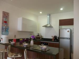 a kitchen with a refrigerator and a counter top at Central Luxury Apartment Playa del Carmen in Playa del Carmen +21 photos