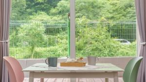 a table in front of a window with a table and chairs at Gapyeong Nature Pension in Gapyeong +6 photos