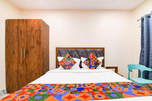 a bedroom with a bed and a blue chair at FabHotel Adhiraj Inn in Kolkata