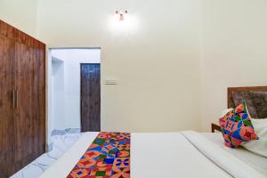 a bedroom with a bed with a colorful comforter at FabHotel Adhiraj Inn in Kolkata