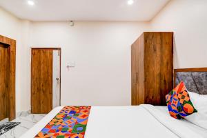 a bedroom with a white bed and wooden doors at FabHotel Adhiraj Inn in Kolkata +28 photos