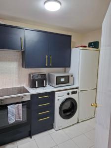 a kitchen with a washing machine and a refrigerator at Family-run 5 Star Home - Consistent Superhosts in Long Lawford