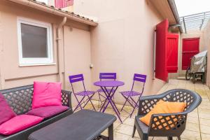 a patio with chairs and a table and a couch at Maison familiale quartier Quentovic in Le Touquet-Paris-Plage