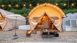 a tent with a table and chairs in front of it at Mungyeong The Most Glamping in Mungyeong +1 photo