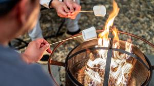 a man is cooking marshmallows over a fire at Mungyeong The Most Glamping in Mungyeong