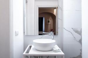 a white bathroom with a sink and a mirror at Florence Eye Accomodations by Hôtea in Florence +24 photos