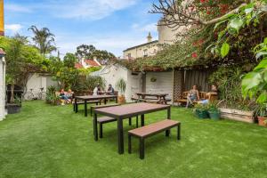 a group of people sitting around tables in a yard at Secret Garden Backpackers, Sydney in Sydney