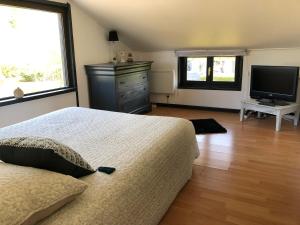 a bedroom with a bed and a flat screen tv at Gîtes Matignon 6 personnes in Matignon
