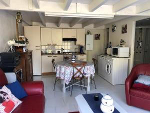 a living room with a table and a kitchen at Gîtes Matignon 6 personnes in Matignon