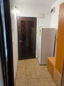 a kitchen with a wooden door and a refrigerator at Studio in Drobeta-Turnu Severin
