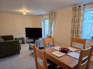 a dining room with a table and a television at Family-run 5 Star Home - Consistent Superhosts in Long Lawford