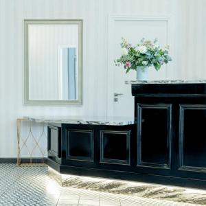 a black cabinet with a vase of flowers on top at Hotel Aria in Nice