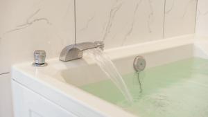 a bathroom with a sink with a water fountain at Gapyeong Ribbon Spa Pool Villa in Gapyeong