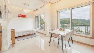 a bedroom with a table and a bed and a window at Gapyeong Ribbon Spa Pool Villa in Gapyeong