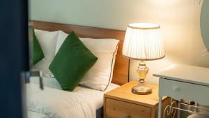 a bedroom with a bed with a green pillow and a lamp at Ganghwado Babavelley Pension in Incheon