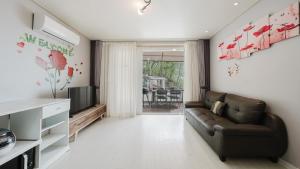 a living room with a couch and a television at Ganghwado Babavelley Pension in Incheon +6 photos