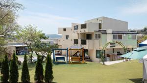 a house with a playground in front of it at Ganghwado Babavelley Pension in Incheon