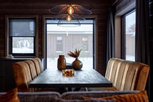 a dining room with a table with chairs and a chandelier at Sigr Hytte 8p With Sauna in Vradal +28 photos