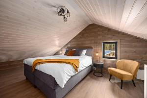 a bedroom with a bed and a chair in a attic at Sigr Hytte 8p With Sauna in Vradal