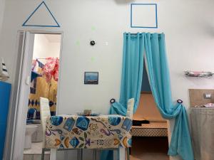a bedroom with a bed with blue curtains at La Stanza del Mare in Calasetta