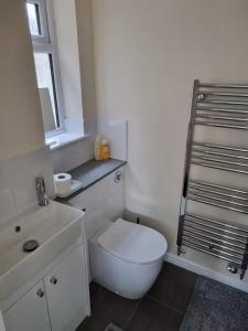 a white bathroom with a toilet and a sink at Family-run 5 Star Home - Consistent Superhosts in Long Lawford +18 photos