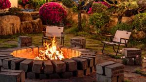 a fire pit in a yard with two chairs at Yeosu Elon Pension in Yeosu