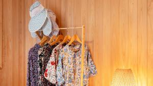 a rack of clothes hanging on a wooden wall at Yeosu Elon Pension in Yeosu