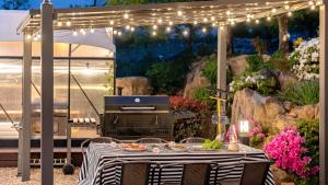 a picnic table with a grill in a garden at Yeosu Elon Pension in Yeosu