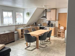 a kitchen with a wooden table and chairs at Apartment Marianne by Interhome in Hooksiel