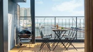 a balcony with a grill and a table and chairs at Sokcho Maru Pension in Sokcho