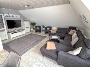 a living room with a couch and a tv at Apartment Marianne by Interhome in Hooksiel