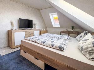 a bedroom with a bed with a tv on top at Apartment Marianne by Interhome in Hooksiel +19 photos