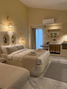 a hotel room with two beds and a kitchen at Fratelli Family Rooms in Tinos