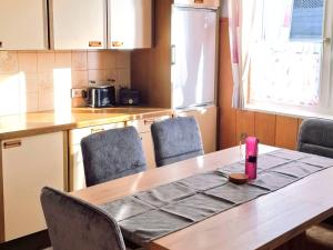 a kitchen with a wooden table with chairs and a table sidx sidx at Holiday Home Katharina by Interhome in Gröbming