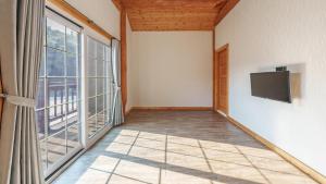 an empty room with a tv and a large window at Daecheon Ocean Forest Pension in Boryeong