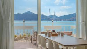 a dining room with a table and a view of the ocean at Yeosu Jangsuri Poolvilla&Spa Pension in Yeosu
