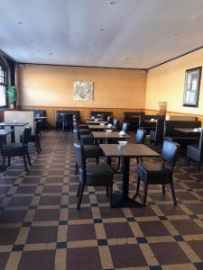 a dining room with tables and chairs in a restaurant at Hôtel Moderne in Gisors