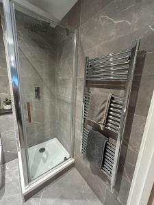 a bathroom with a shower with a glass shower stall at The Courthouse Stylish Serviced Living in Ramsgate +21 photos
