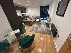 a living room with a glass table and green chairs at The Courthouse Stylish Serviced Living in Ramsgate