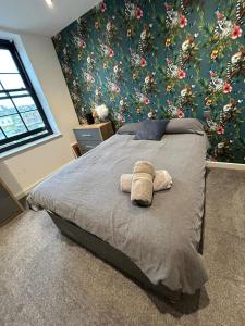 a bedroom with a bed with a stuffed animal on it at The Courthouse Stylish Serviced Living in Ramsgate