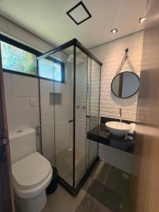 a bathroom with a toilet and a sink and a mirror at Oby Noronha in Fernando de Noronha
