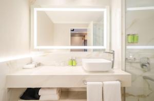 a white bathroom with a sink and a mirror at Holiday Inn Rosario by IHG in Rosario