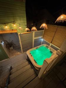 a hot tub sitting on top of a deck with lights at Le Cocoon SPA du MAIDO in Le Guillaume