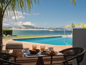 a table with a tray of food next to a pool at Ionian Hill Hotel in Argassi