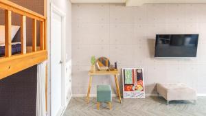 a room with a table and a tv on a wall at Goseong CNBLUE Oceanview Pension in Goseong