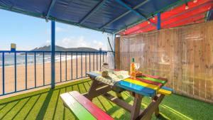 a table and two chairs on a balcony with a beach at Goseong CNBLUE Oceanview Pension in Goseong +5 photos