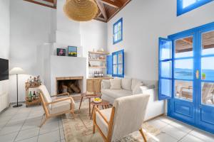 a living room with a couch and a fireplace at Villa Cleio where the sea meets absolute calm in Skiathos